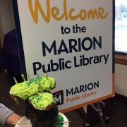 Sign for Marion Public Library next to donut diorama 