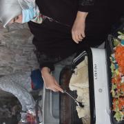 Photograph of a person serving rice from a tray