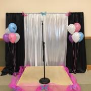 A stage for the tea party is decorated with balloons and butterflies.