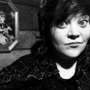 Photo of scary story teller in black and white with spooky background.