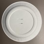 Photograph of a paper plate with two slits cut in the middle