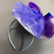 Photograph of a finished fascinator with purple loofah and tulle