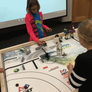Child places LEGO robot on table