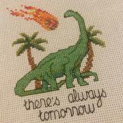 Cross stitch of dinosaur with meteor. Text reads "there's always tomorrow."