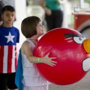 Girl holding large red ball decorated with Angry Bird face