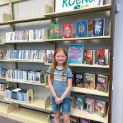 Photograph of Kid Librarian posing in front of display.