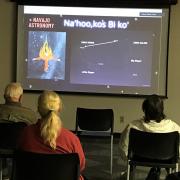  Photo from Navajo Astronomy. Screen shows the slide of presentation with three people facing the screen.