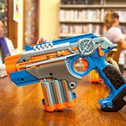 A nerf phaser that is used for laser tag rests on top of a table.