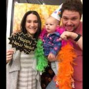 A couple with a baby in the photobooth 