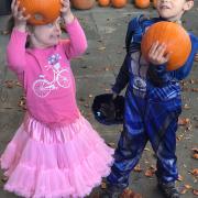 Two children holding pumpkins