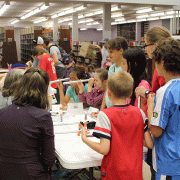 Kids gathered around a table making spectroscopes
