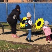 Photograph shows kids and parents using the outdoor flower petal drums. 