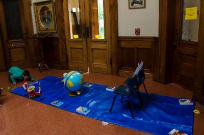 boy playing mini-golf by our portrait of LP Fisher, our library's namesake