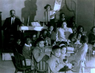 Black and white photo of children around a table at Sunday School.