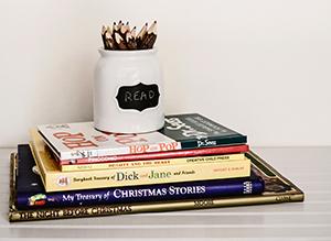 Stack of children's books with a pencil holder sitting on top that says "read" photo by Debby Hudson on Unsplash