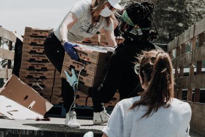 Person passing boxes of food off a truck