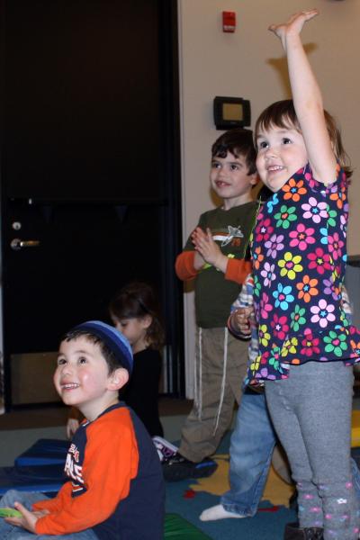 kids raising their hands during a program