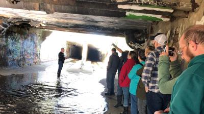 A man presents to group in an underground tunnel