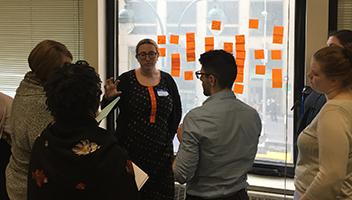 NYPL stand at a window discussing notes on post-its