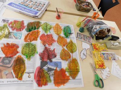 Painted leaf cutouts on newspaper