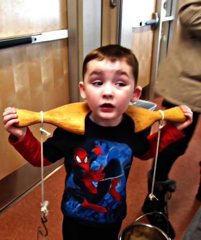 A boy carries water using a yoke