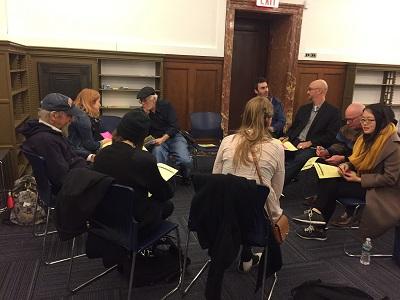 A group of nine people sitting in a circle and talking 