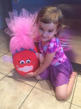 Little girl holding her painted pumpkin