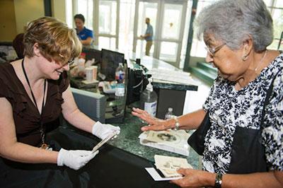 A woman consulting with an expert at the library on her family photographs