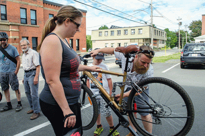 Man working on a bicycle while a woman looks on