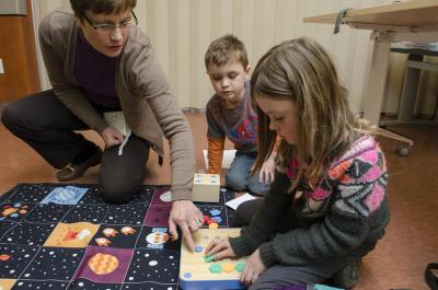 Teacher helping kids with Cubetto