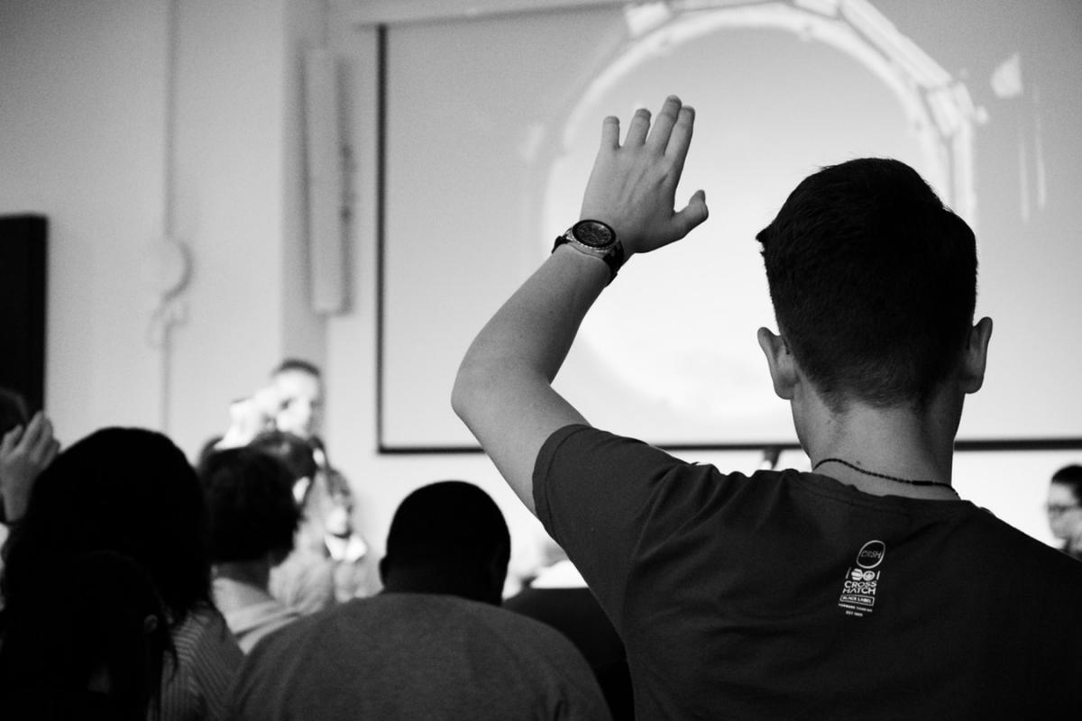 person raising hand during presentation